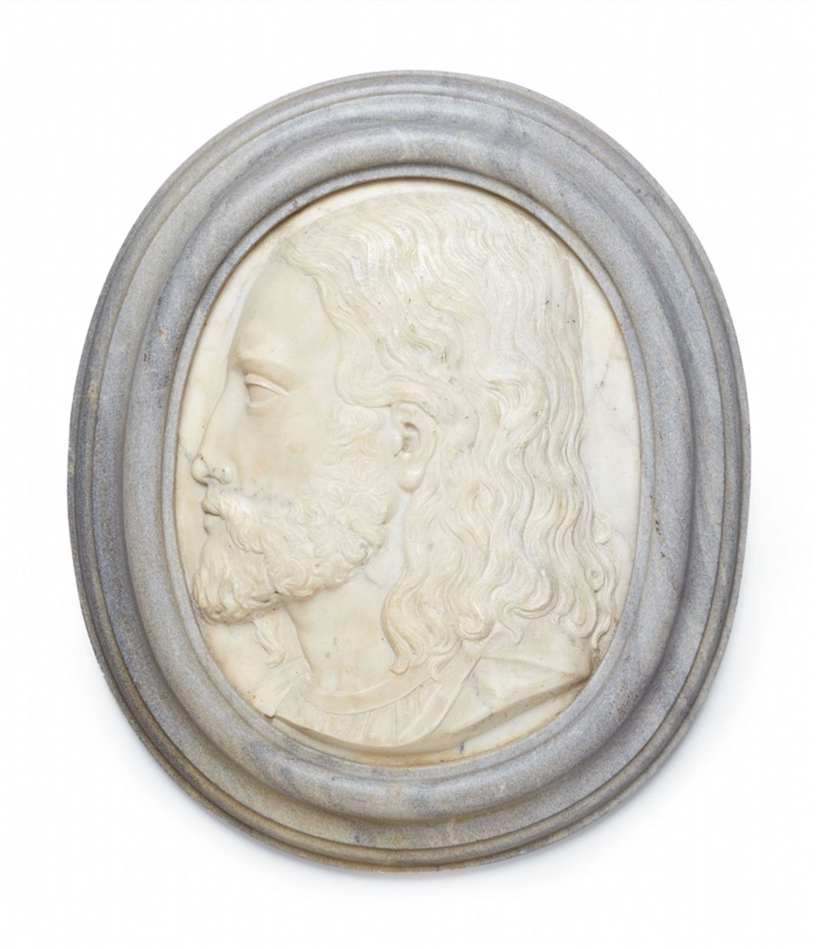 A marble relief plaque with the head of a young manOval white marble plaque depicting a bust of a