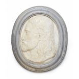 A marble relief plaque with the head of a young manOval white marble plaque depicting a bust of a