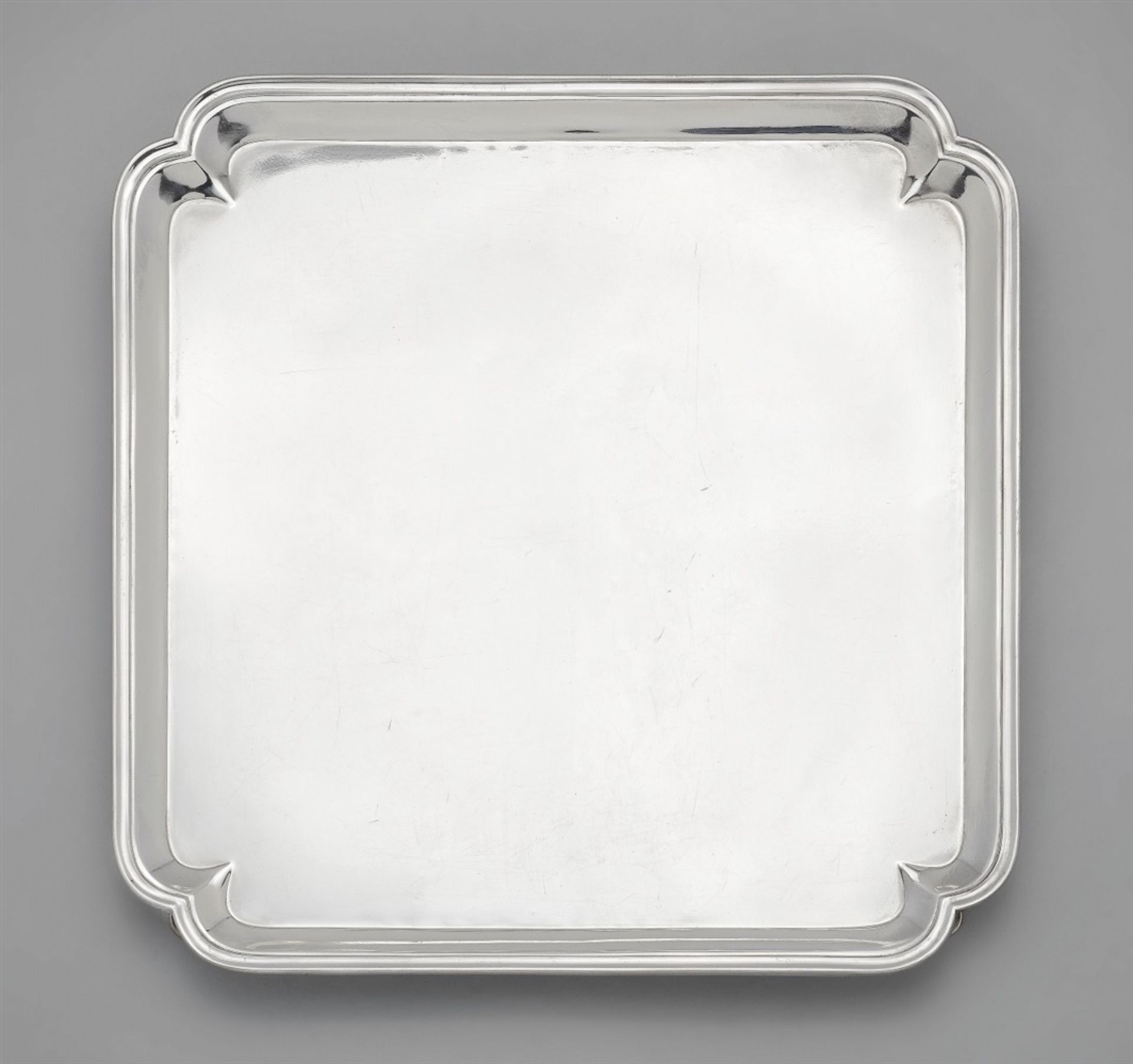 A George I silver salverRectangular platter on four supports with a narrow moulded rim.