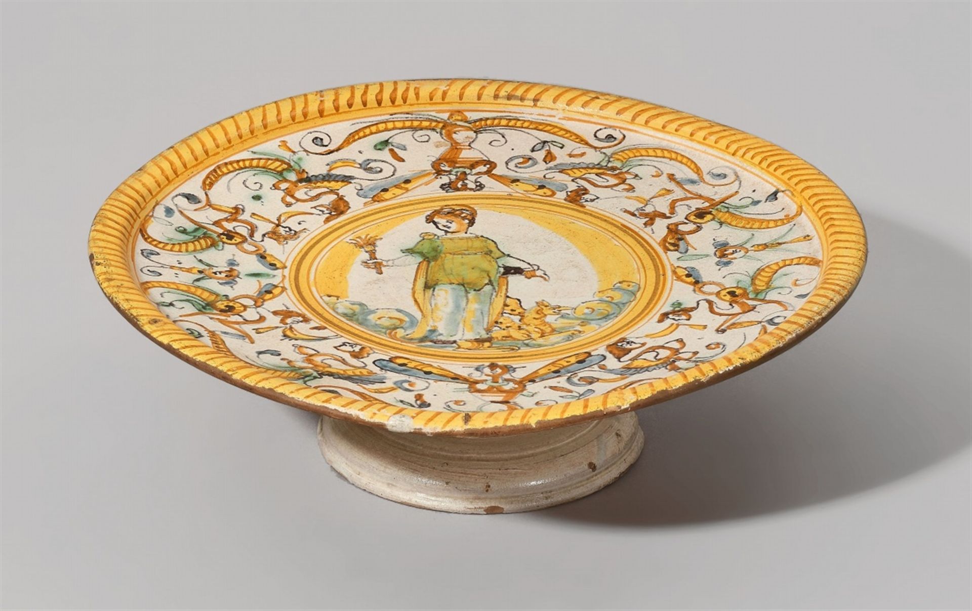 An Italian maiolica serving platterA shallow dish with a raised rim on a moulded flaring foot.