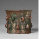 A rare Sanskrit mortarCast and chased bronze with remnants of red pigment. Cylindrical form with