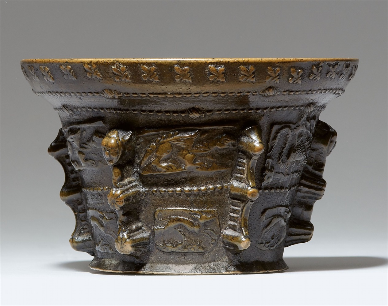 A magnificent French ribbed mortar with animal motifsGolden brown cast bronze with shimmering