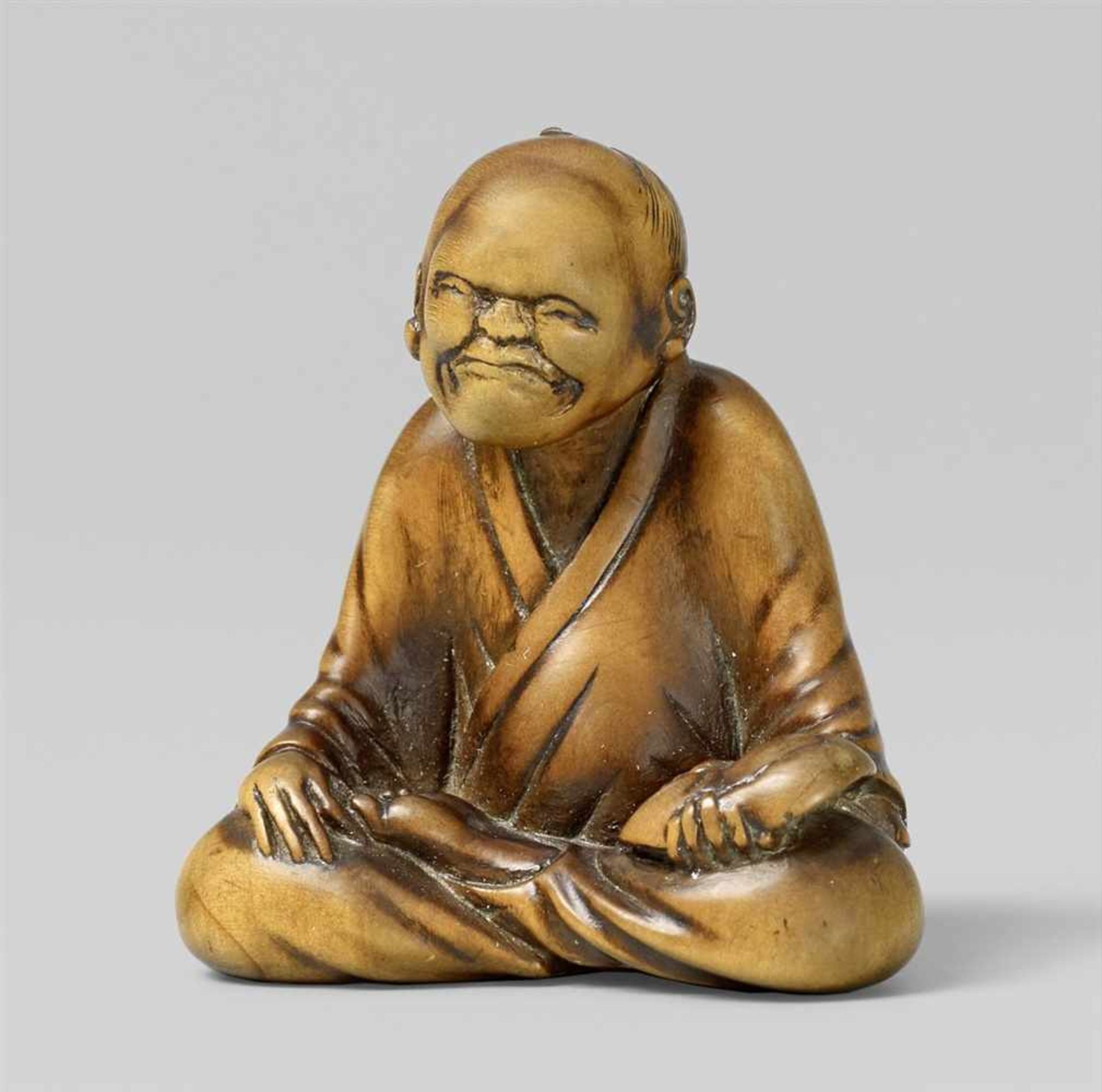 A boxwood netsuke of a mask carver. Early 19th century