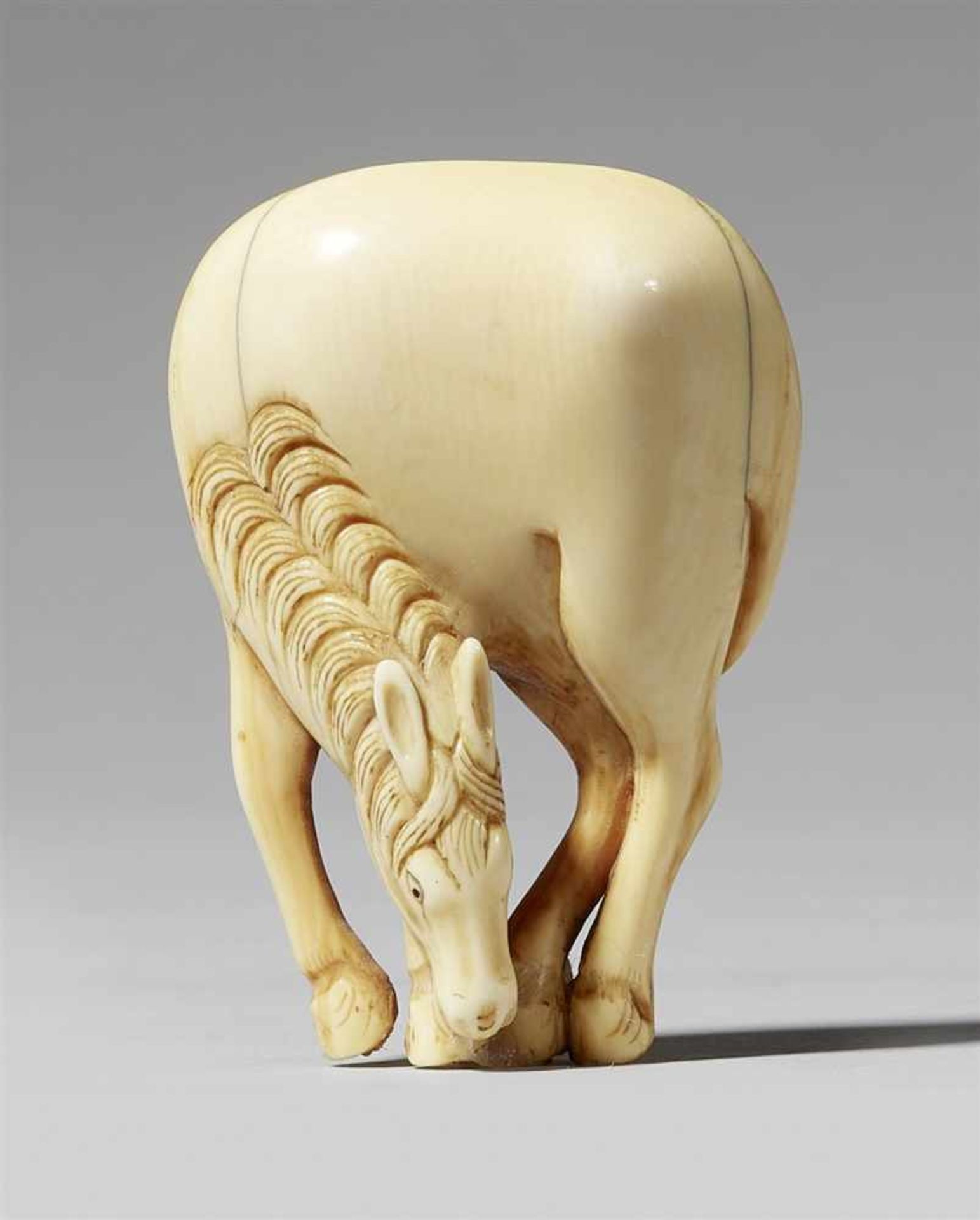An ivory netsuke of a grazing horse. Late 19th century