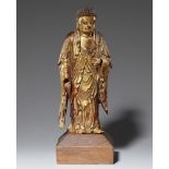 Stehender Buddha. Holz, über einer rotbraunen Lackschicht, vergoldet. Südchina. 19. Jh.