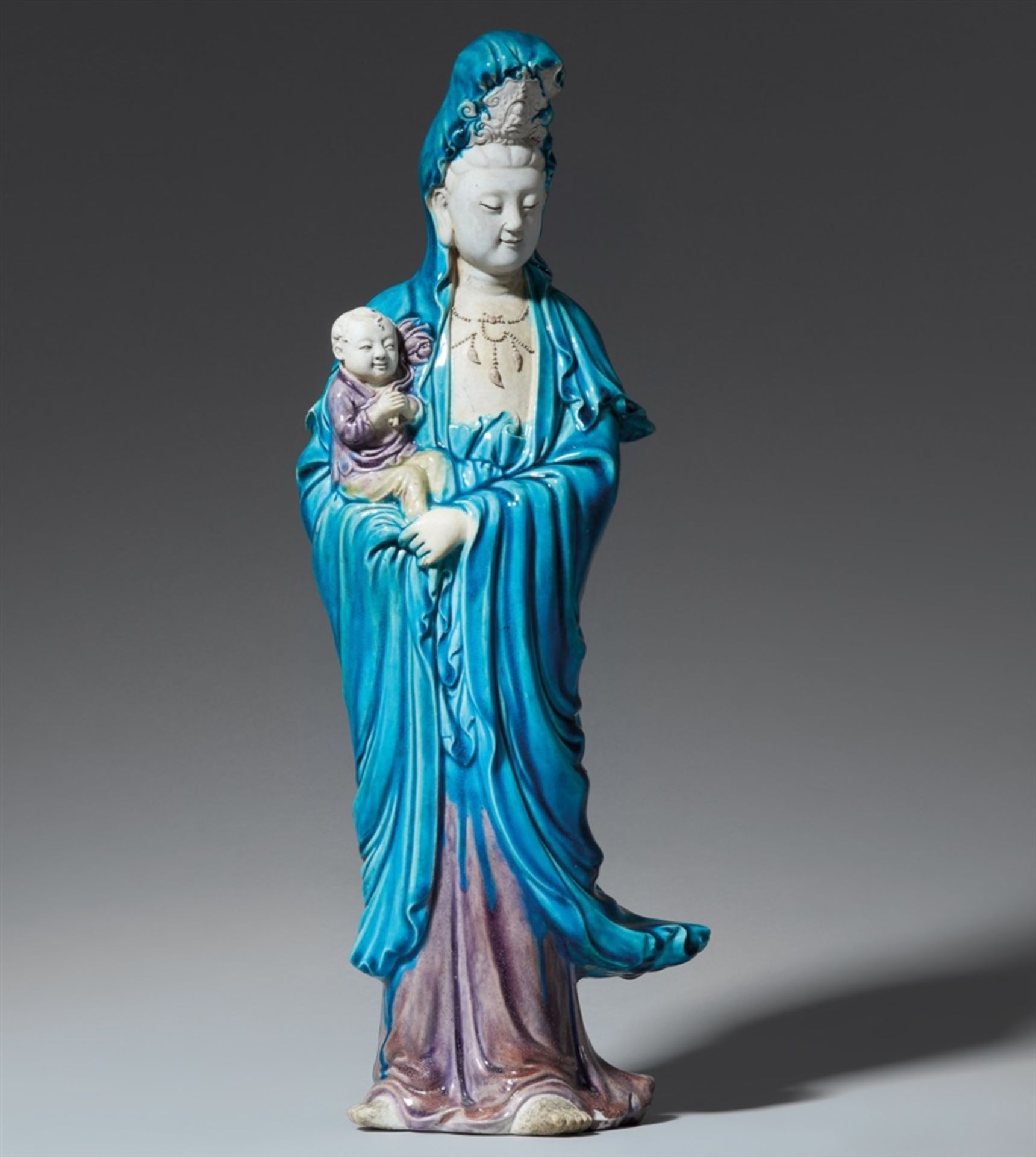 Türkis- und aubergine-farbig glasierte Guanyin-Figur mit Kind. 19. Jh.