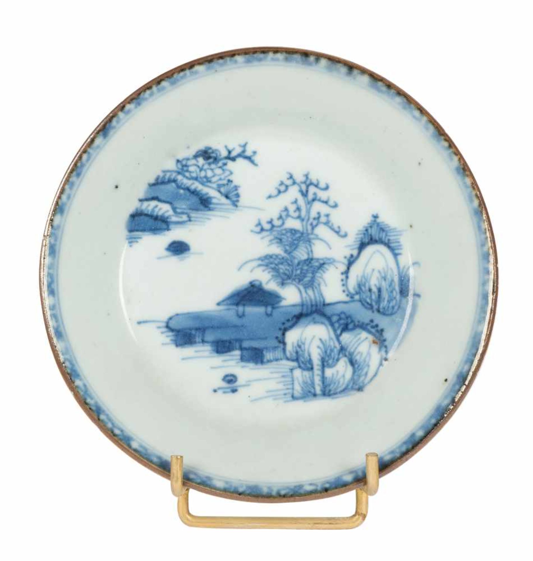 An saucer dish in blue and white porcelain depicting a central scene with a landscape. China. Qing