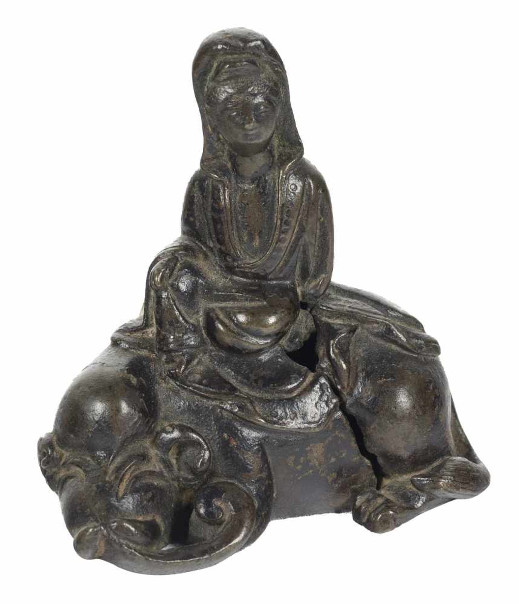 A small bronze figure of a Guanyin seated on a mythical beast. China. Ming dynasty (1368-1644).