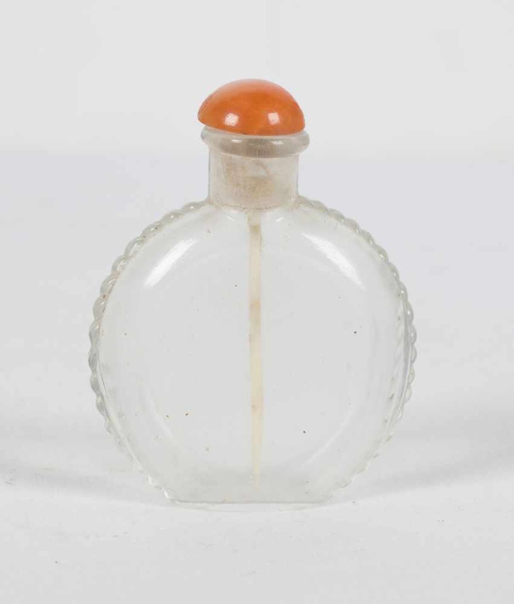 A carved rock crystal snuff bottle. China. Qing dynasty. 19th Century. Pink coral stopper. Heig