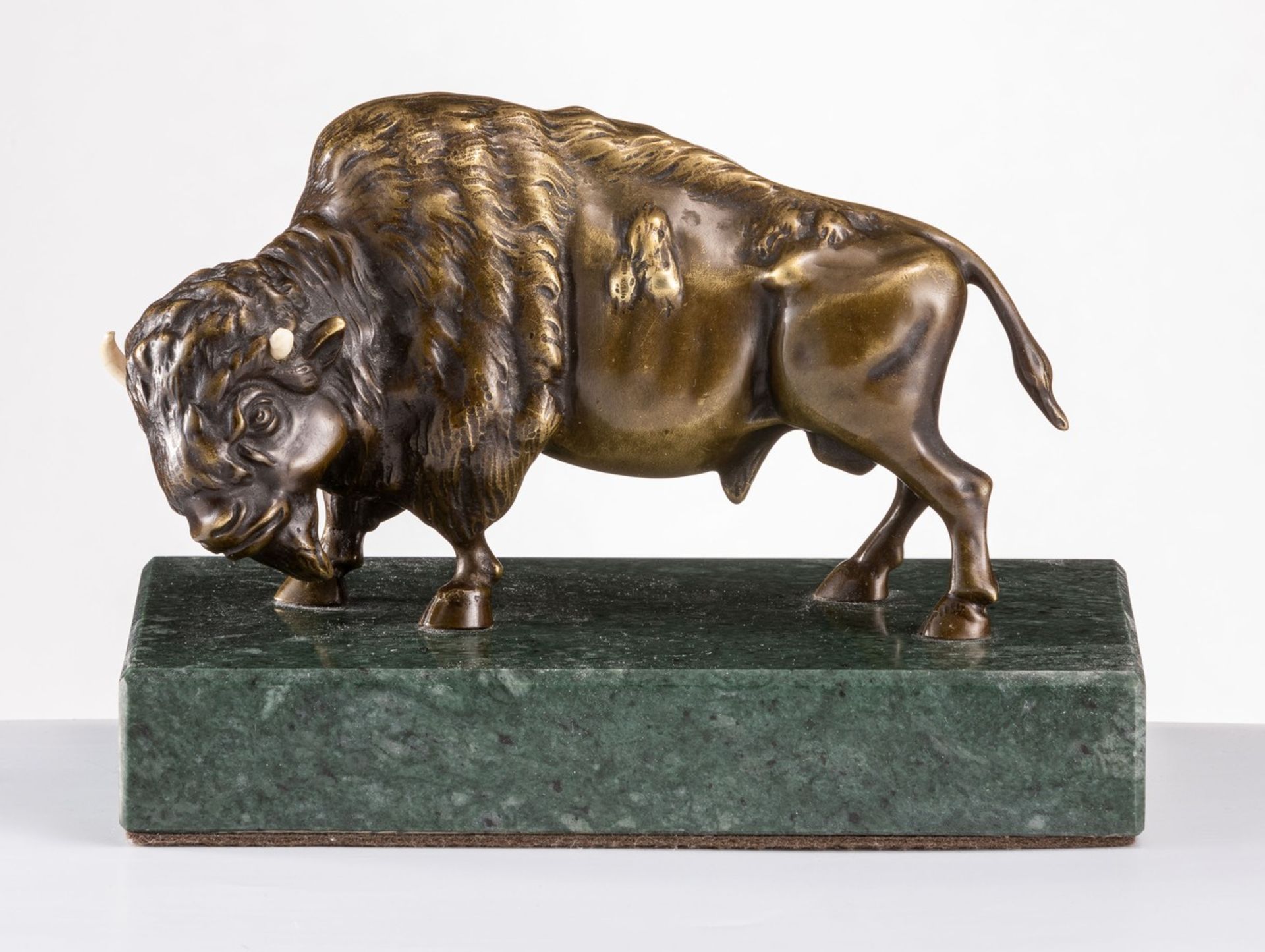 BisonMit Beinhörnern. Bronze, dunkel patiniert. H. 10 / Lg. 16,5 cm. Auf grünem Marmorsockel, D. 3×