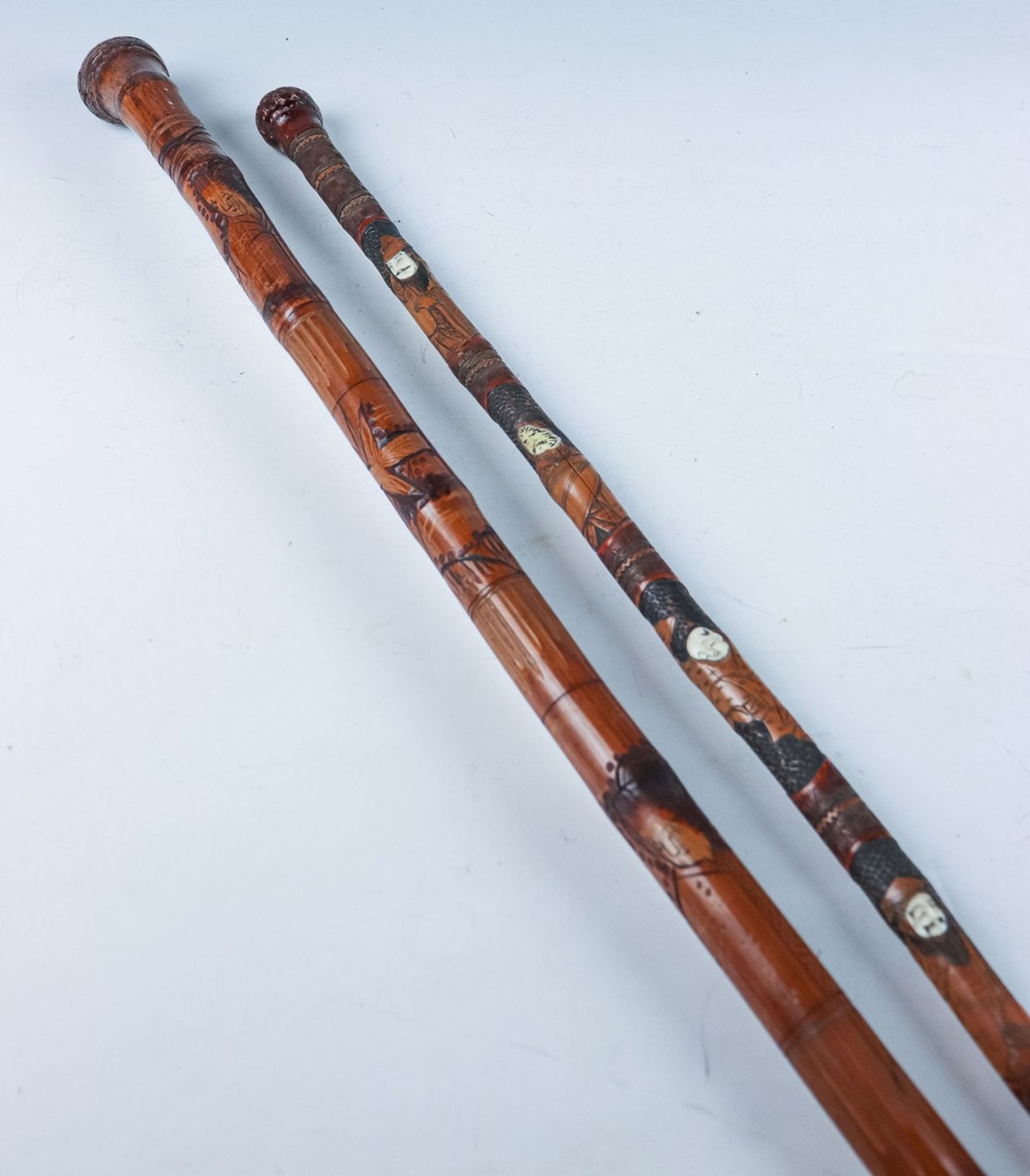 Zwei japanische SpazierstöckeA. 20. Jh.Bambus, geschnitzt und eingefärbt. Wurzel als Knauf mit