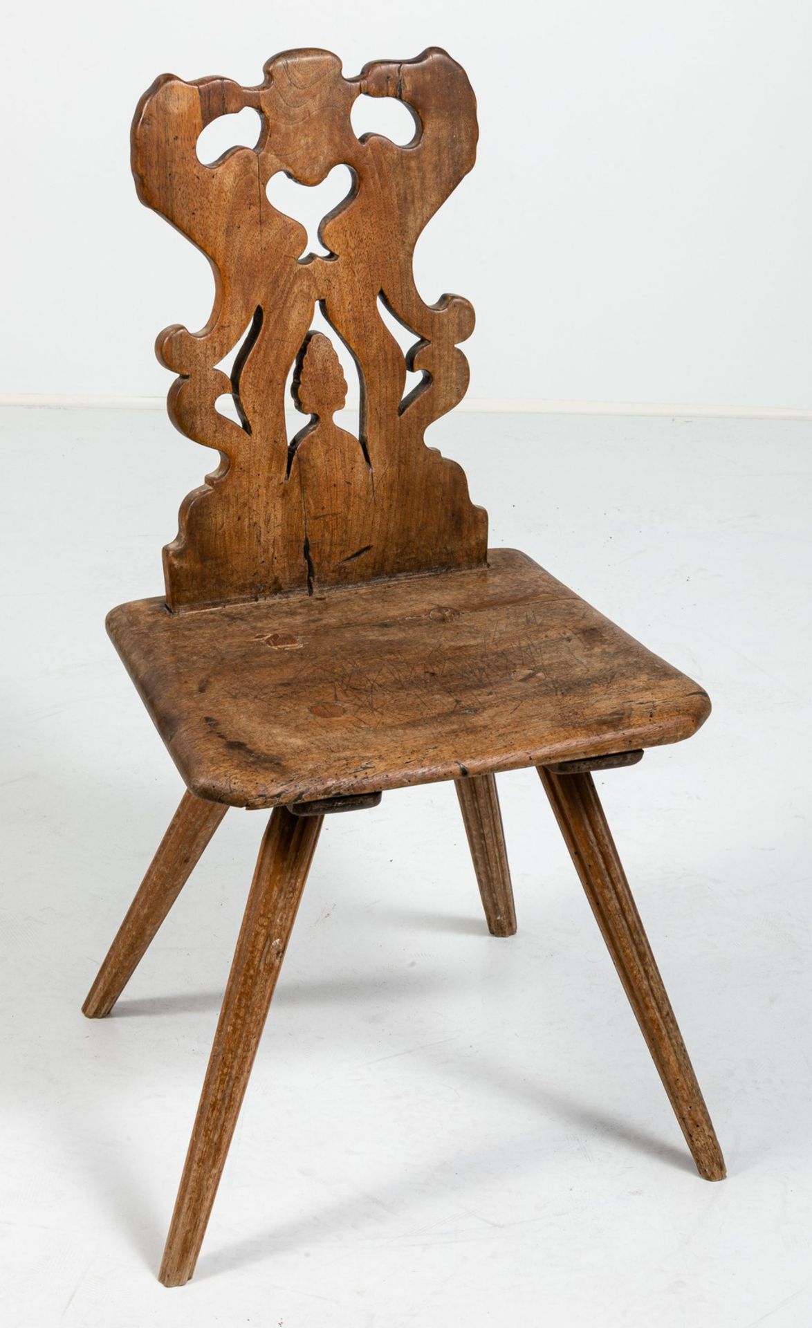 Brettstuhl18. Jh. Nussbaum. Trapezförmiger Sitz auf schräg gestellten kannelierten Säulenbeinen (