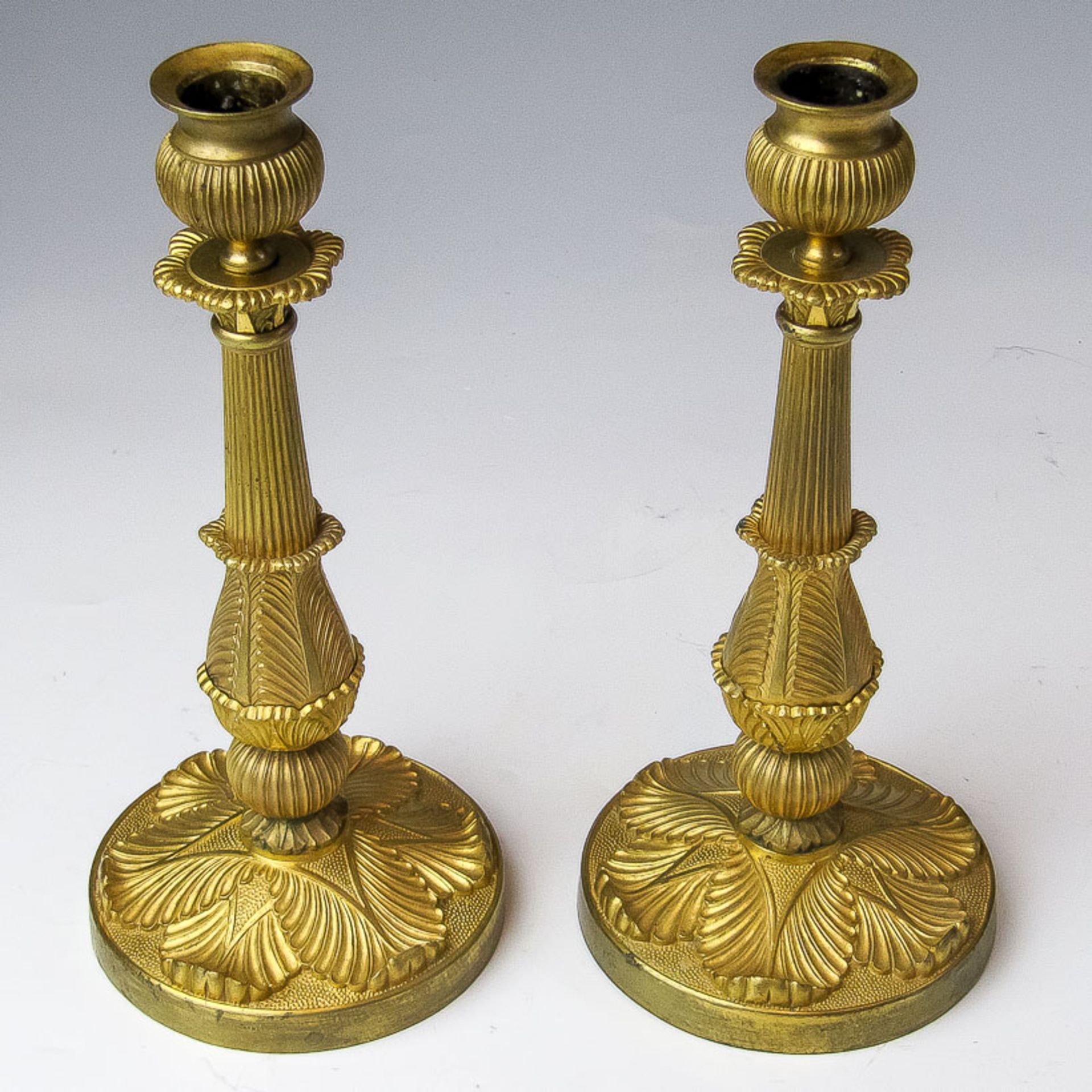 Ein Paar Leuchter im Empire-Stil19. Jh.Messing, vergoldet. Runder Fuß mit reliefiert