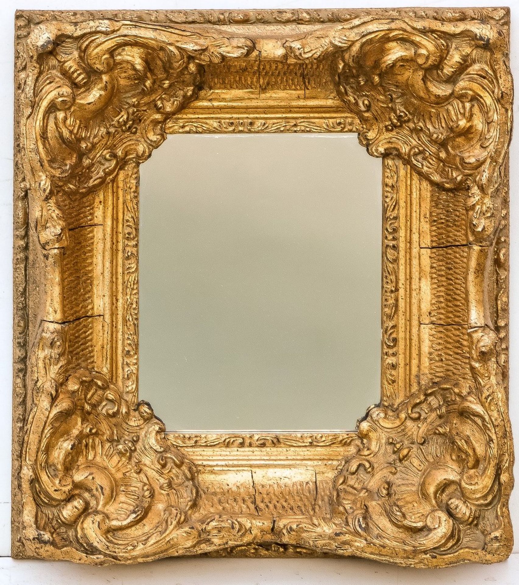 Kleiner Rahmenspiegel im BarockstilHolz und Stuck, vergoldet. Breiter, geschweifter Rahm