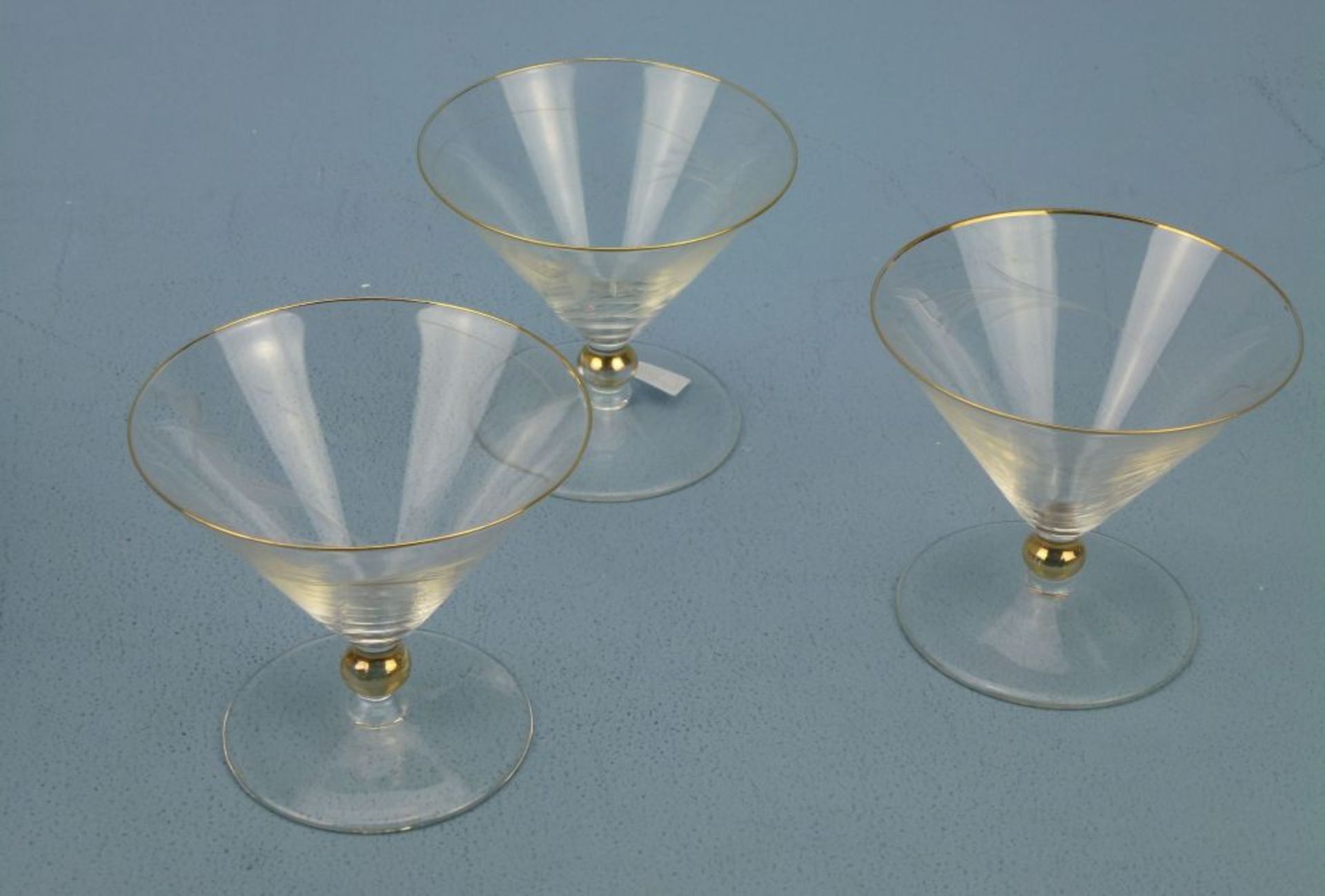 3 SektschalenRichard Süssmuth?, 1900 - '74klares Glas, trichterförmig, Gold-Nodus u. -Rand, Figurine