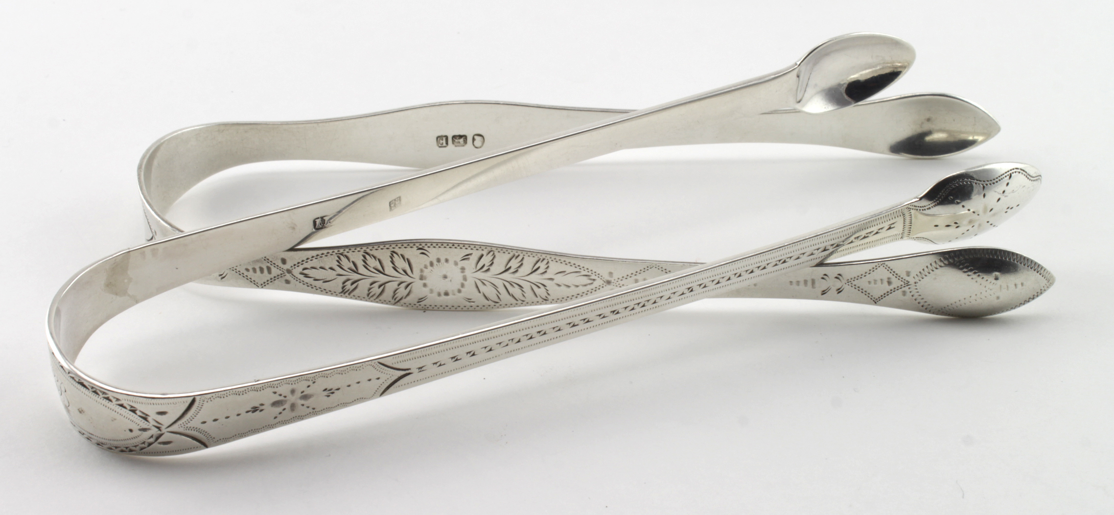 Two pairs of silver, bright-cut Georgian sugar tongs - one is hallmarked Peter, Ann & William
