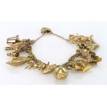 Yellow metal (tests as 9ct) charm bracelet with a variety of charms attached. Total weight 28.2g