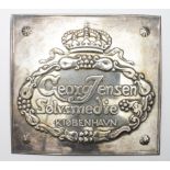 Georg Jensen silver plated plaque, reads 'George Jensen, Solvsmedie, Kiobenhavn [Copenhagen]', 11.