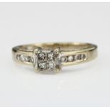 18ct White Gold ring set with central cluster of four princess cut Diamonds with channel set Diamond