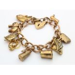 9ct / Yellow metal charm bracelet with a good variety of charms attached, total weight 35.7g