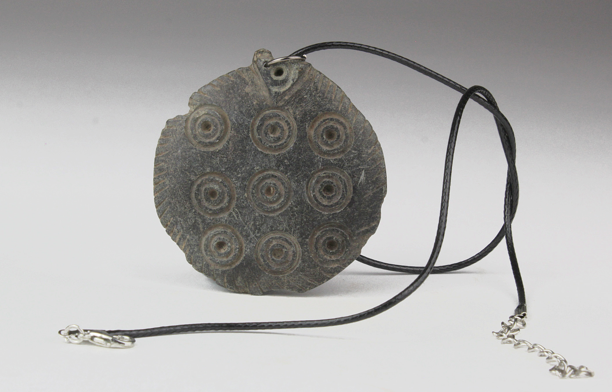 Gandhara Schist Pendant, C. 300 A.D. Gandharan Schist Pendant with Sun motif. 9 large sun symbols