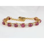 18ct yellow gold bracelet set with alternating round cabochon cut rubies and cz set links with box
