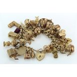 Very heavy 9ct/Yellow metal charm bracelet with a large selection of charms attached. total weight