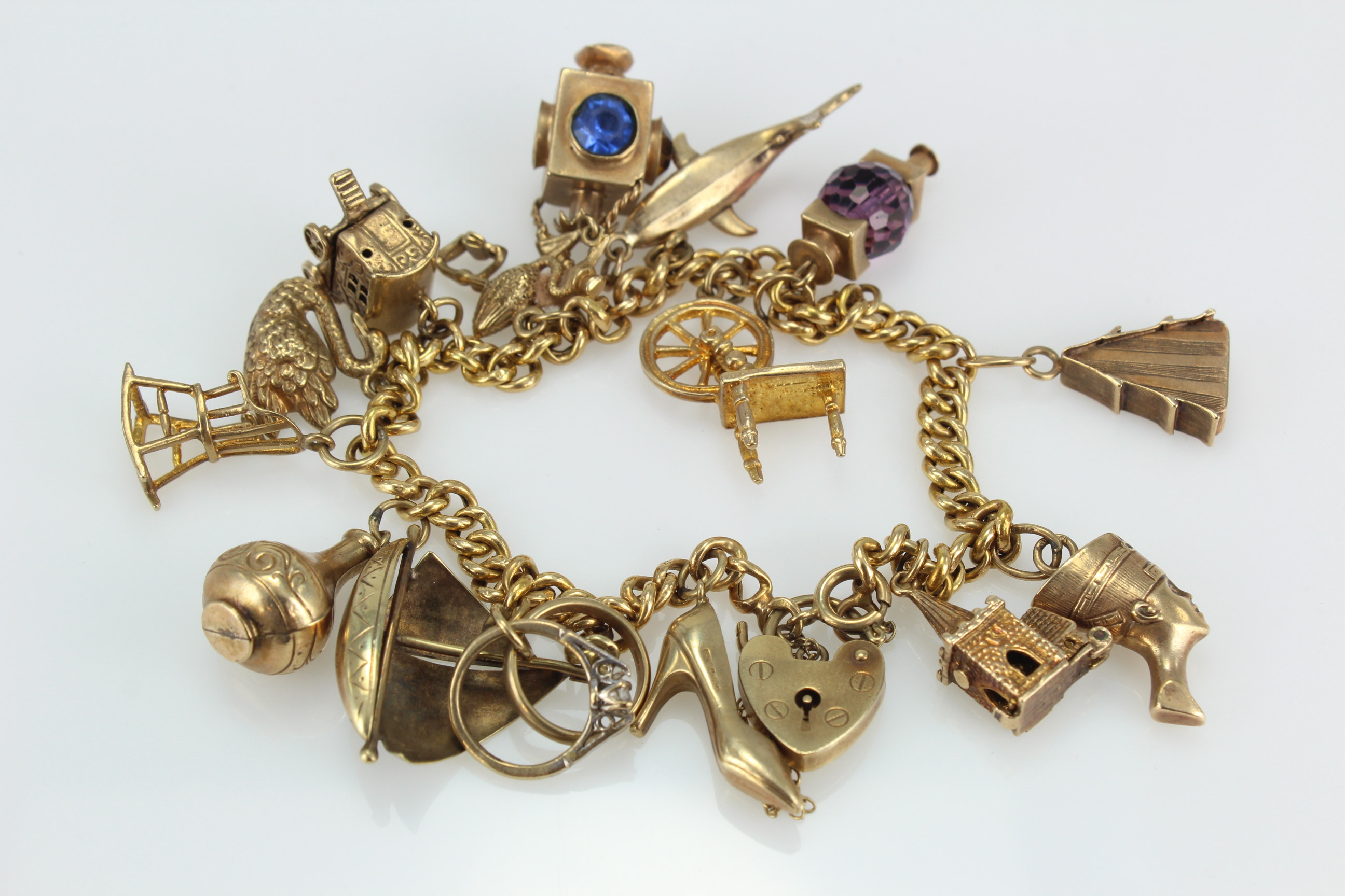 9ct/Yellow metal charm bracelet with a selection of charms attached. total weight 37.8g