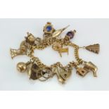 9ct/Yellow metal charm bracelet with a selection of charms attached. total weight 37.8g