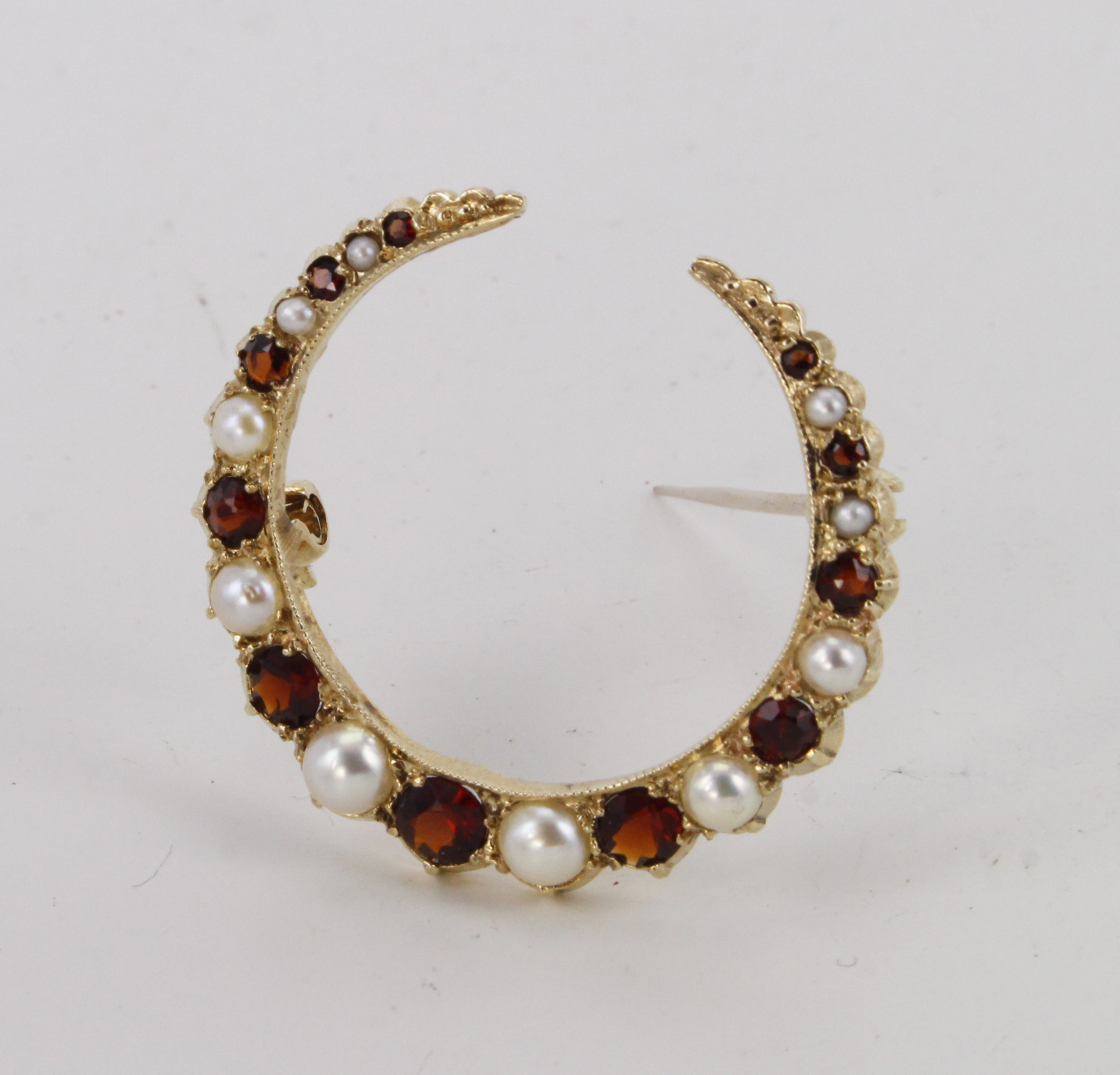 9ct crescent brooch set with garnet and pearl, weight 3.8g