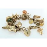 9ct/Yellow metal charm bracelet with a good variety of charms attached. total weight 62.8g