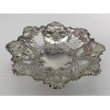 Ornate silver fruit dish showing fruits & flowers on three ball feet, hallmarked 'E & Co., Ld.,