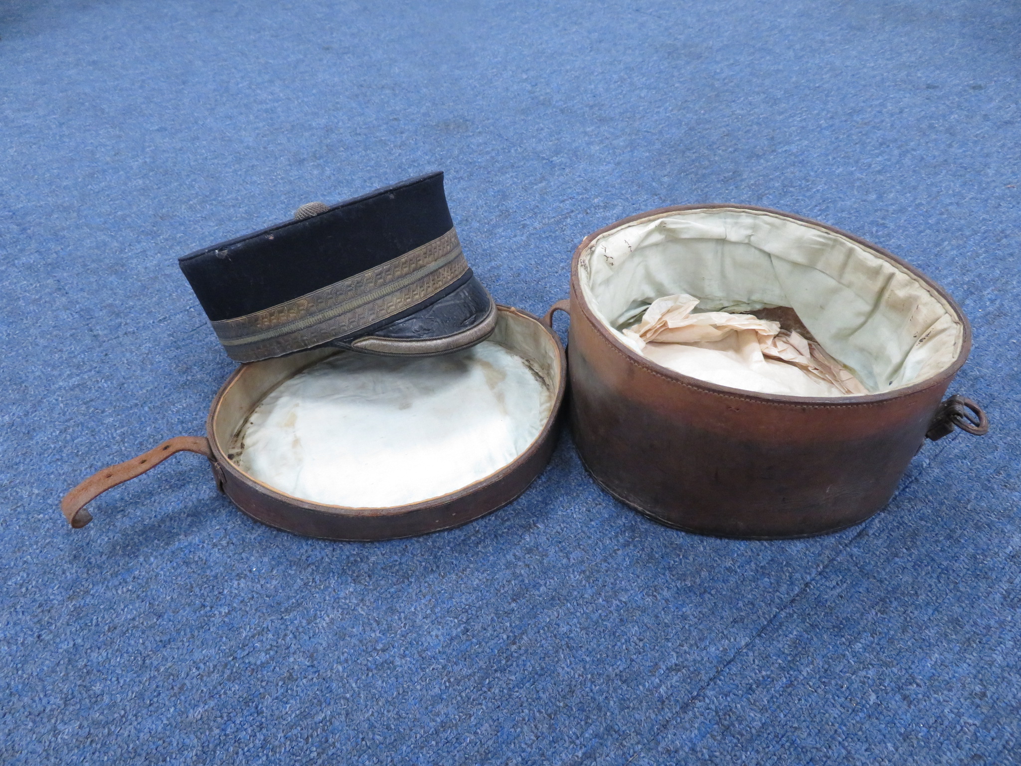 Victorian officers pillow box hat, in blue cloth with black leather peak housed in a brown leather