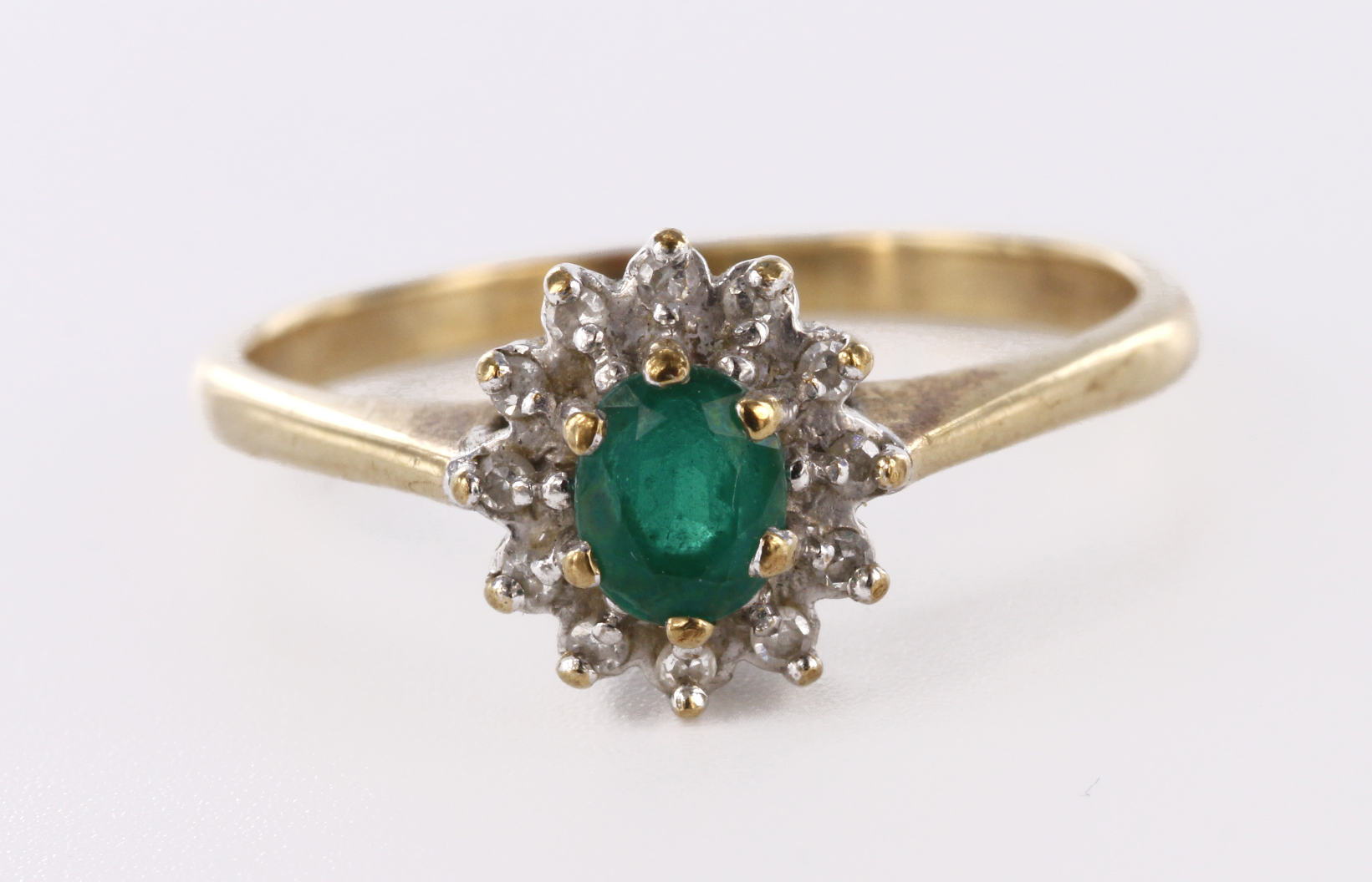 9ct yellow gold cluster ring set with central oval emerald surrounded by twelve diamonds totalling