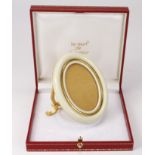 Le Must de Cartier cream enamel picture frame, with easel back, contained in original case, frame