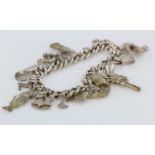 Silver / White metal charm bracelet with a variety of charms attached, total weight 67.1g