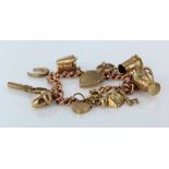 9ct / Yellow metal charm bracelet with a selection of charms attached. Total weight 37.3g