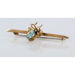 Yellow metal (marked 9ct) spider shaped bar brooch set with a pearl and an oval cut blue stone.