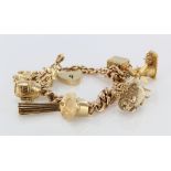 9ct / Yellow metal charm bracelet with a good selection of charms attached. Total weight 56.4g