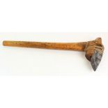 An unusual stone axe with wooden carved handle, circa 19th Century (?), possibly indonesian, blade