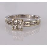 18ct white gold ring set with four princess cut diamonds clustered together in an invisible