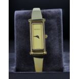 Ladies Gucci gold plated bracelet wrist watch with gold dial and stirrup clasp, box and papers,