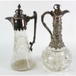 Two white metal mounted cut glass claret jugs, height 30cm approx.