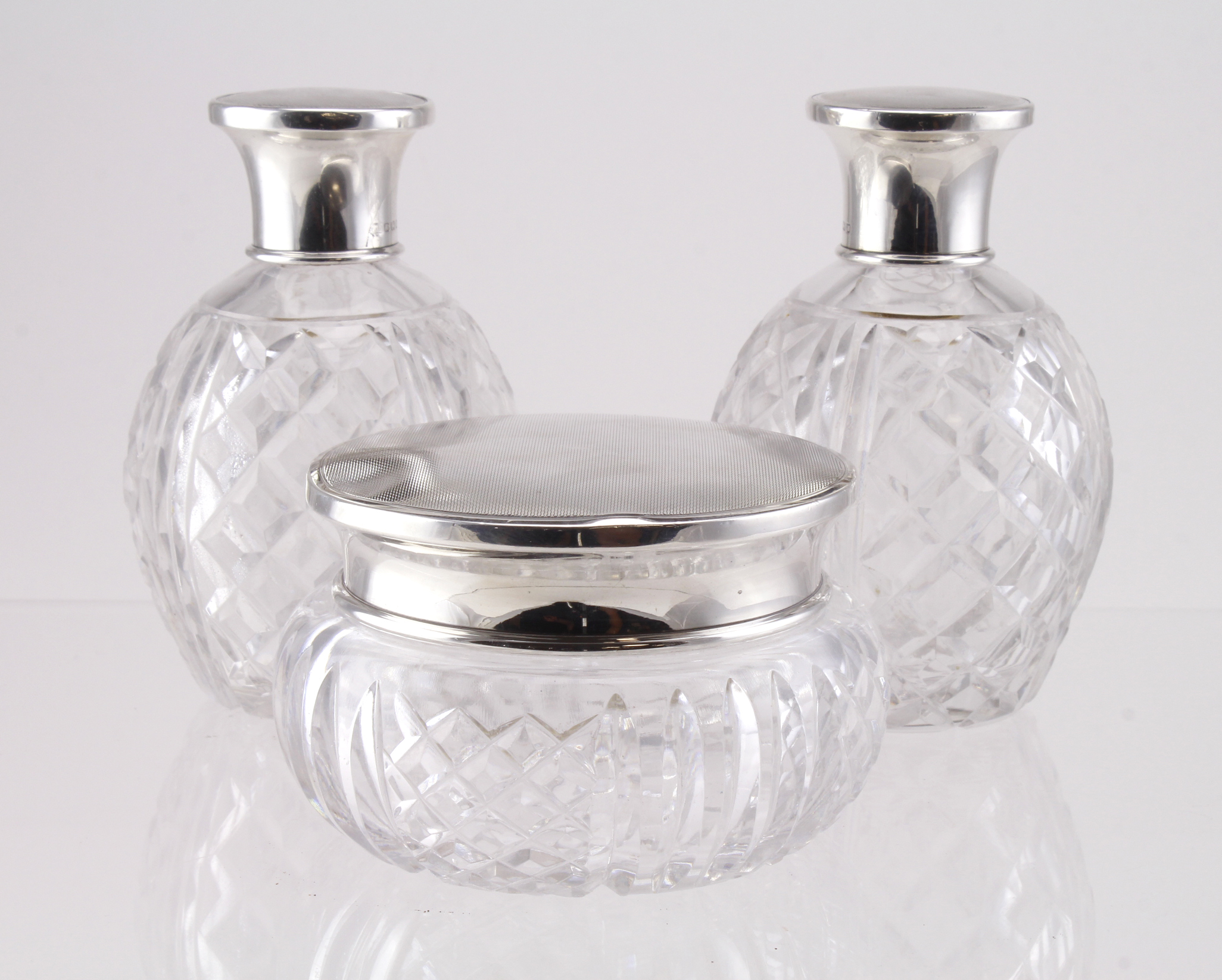Three silver topped cut glass scent bottles & jar, hallmarked 'Mappin & Webb, London 1945',