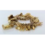 9ct / Yellow metal charm bracelet with a good mixture of charms attached. Total weight 52.9g