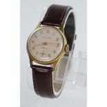 Mid sized gold plated Kienzle manual wind wrist watch on a brown leather watch strap, champagne dial