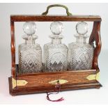 Oak three decanter tantalus, with brass mounts, a few chips, height 32cm, width 36cm, depth 14cm