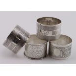 Four silver napkin rings comprising two decorated Victorian rings hallmarked Birm, 1881 and