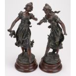 Two decorative spelter female figures, on turned wooden bases with small plaques read 'Chant du