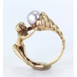 Ornate Yellow metal (tests 9ct) Ring of Swimmer supporting a Pearl Trophy size R weight 12.5g